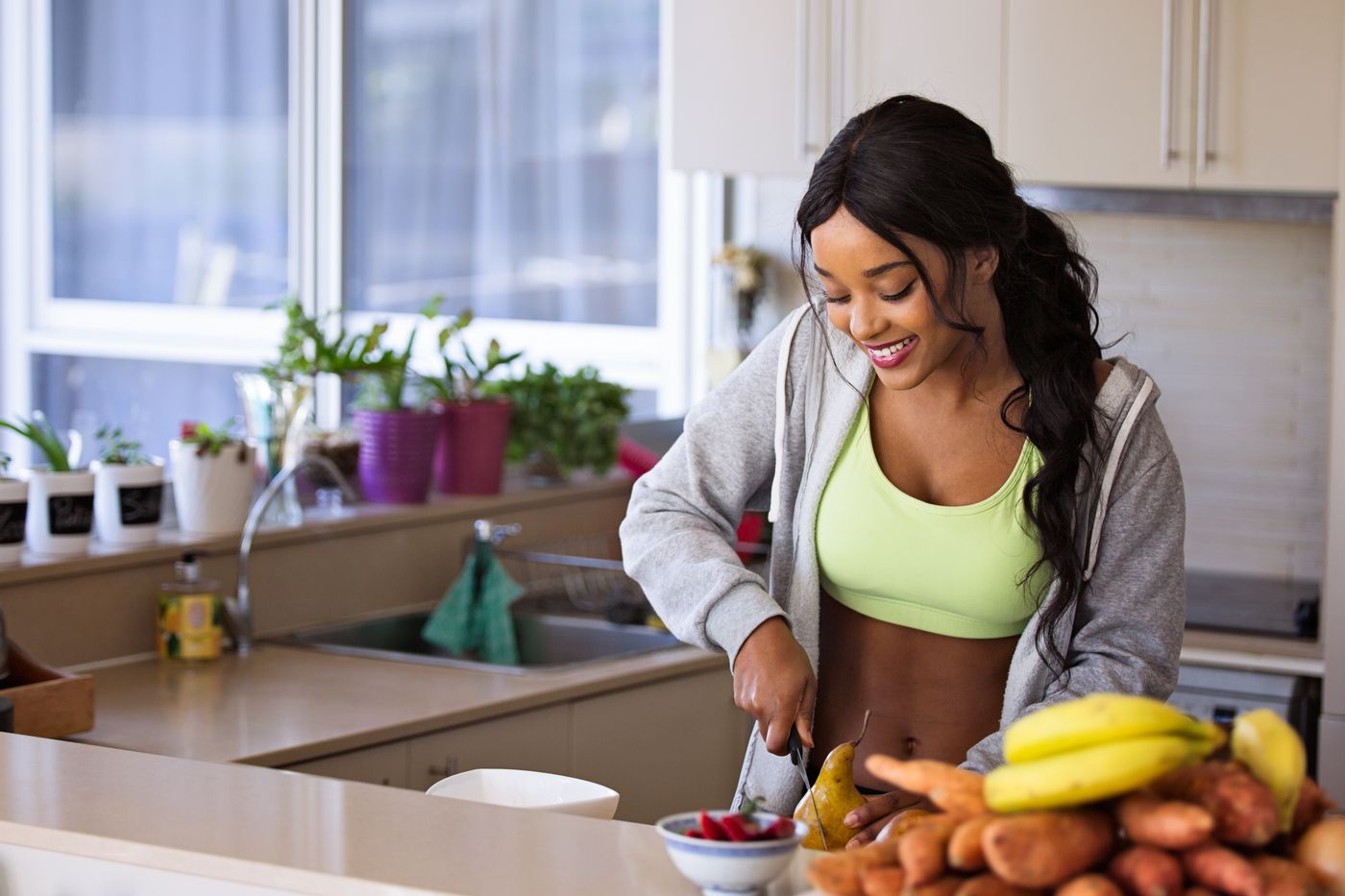 Woman preparing fruit and vegetables in a bright kitchen